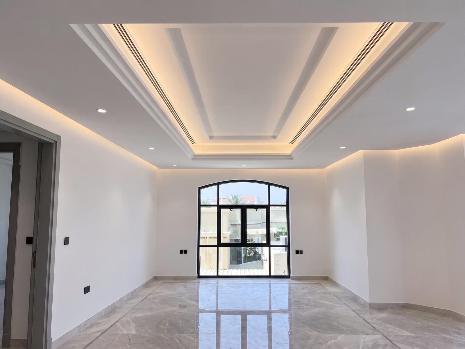 A black steel arched window over polished marble flooring