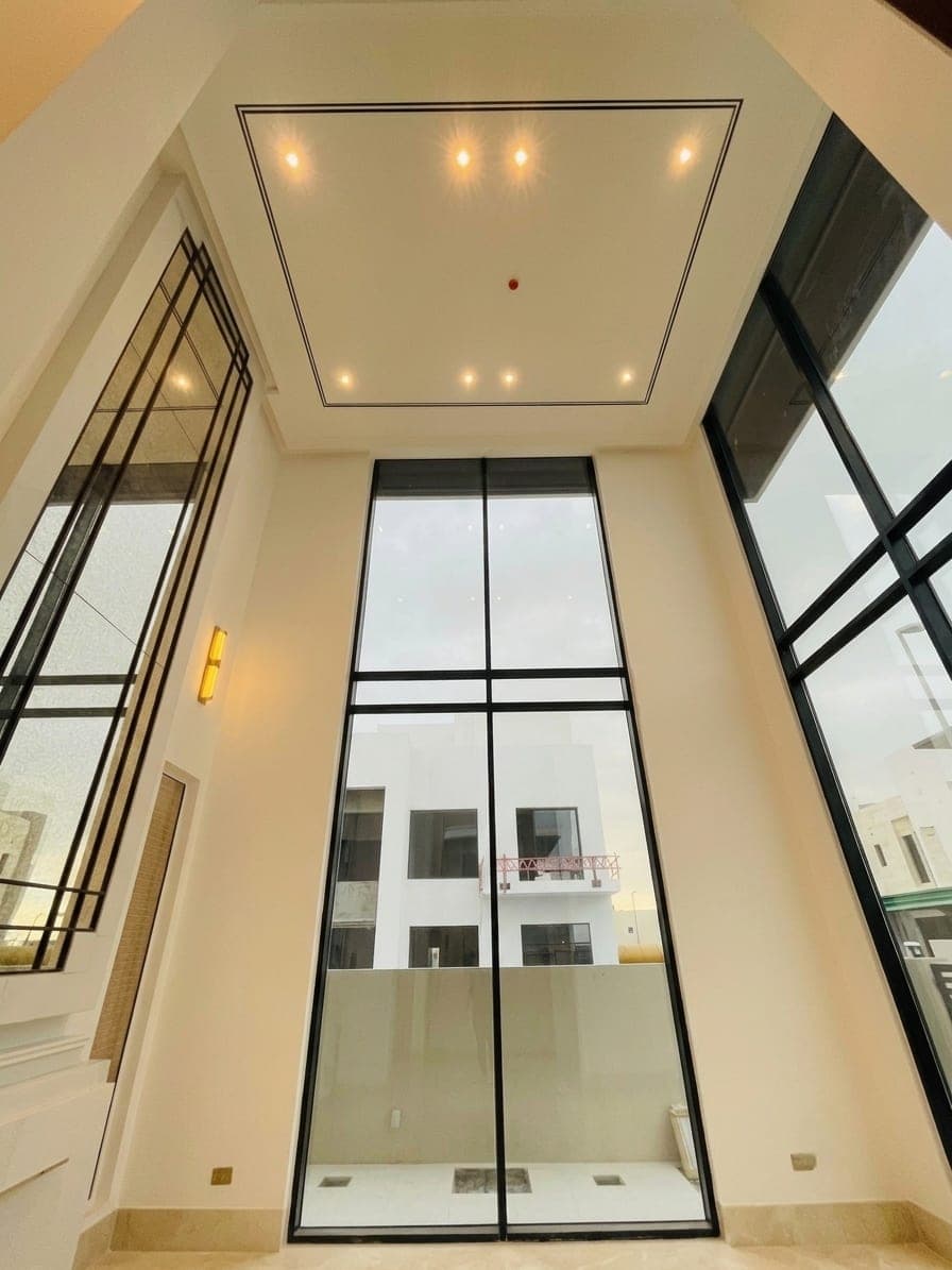 The double-height void, glazed on two sides in black-framed glass