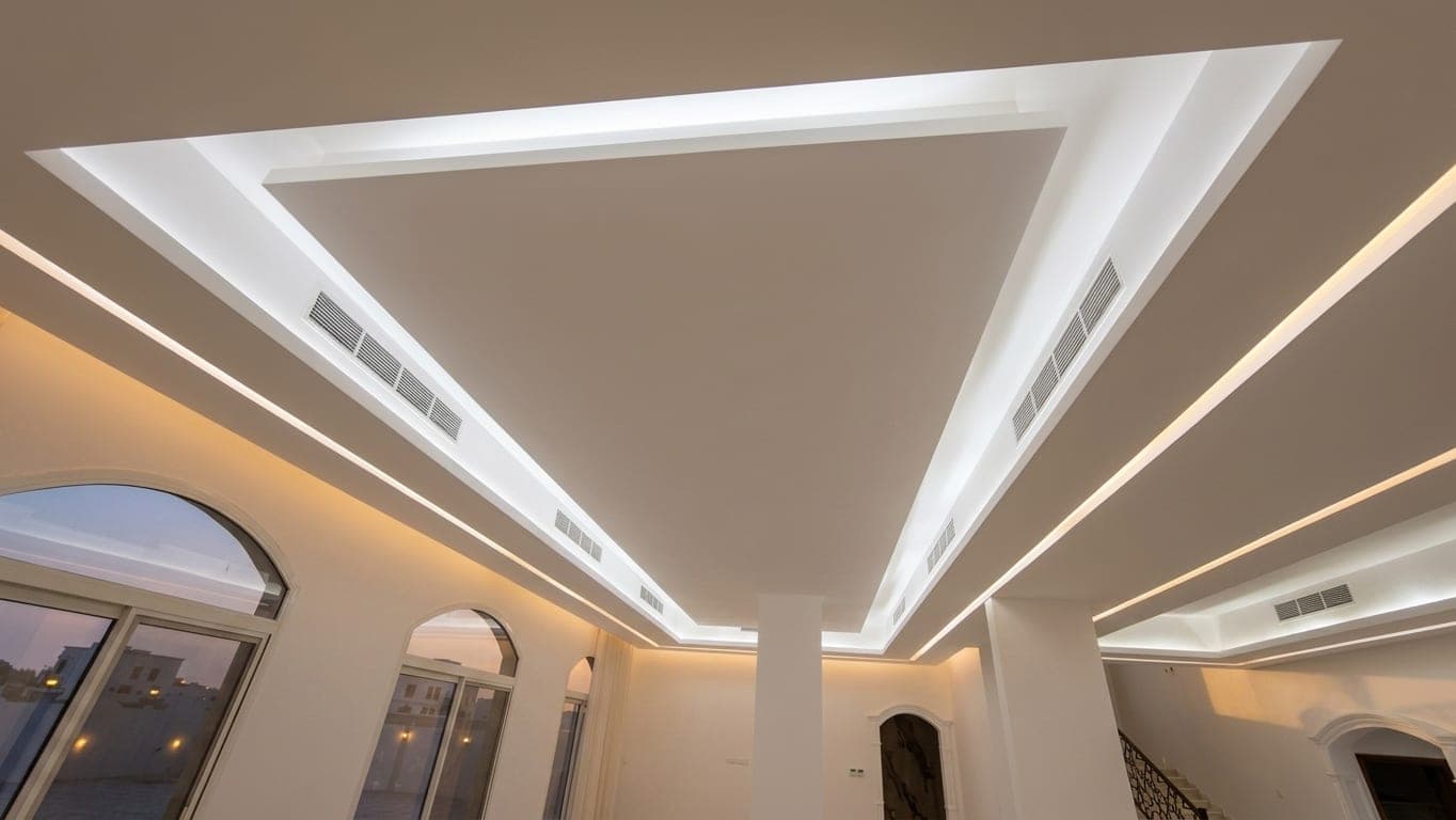 A cove-lit tray ceiling above an arched window
