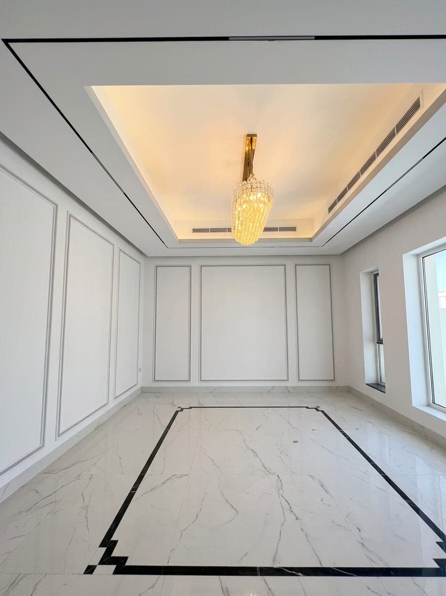 A formal room with panelled walls and an inlaid marble floor border
