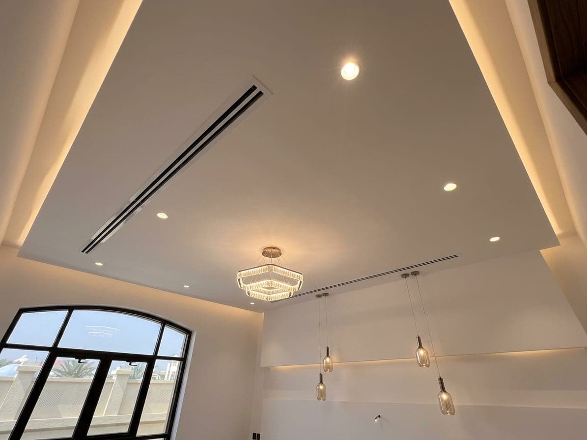 A warm reception with arched windows, linear lighting and a chandelier