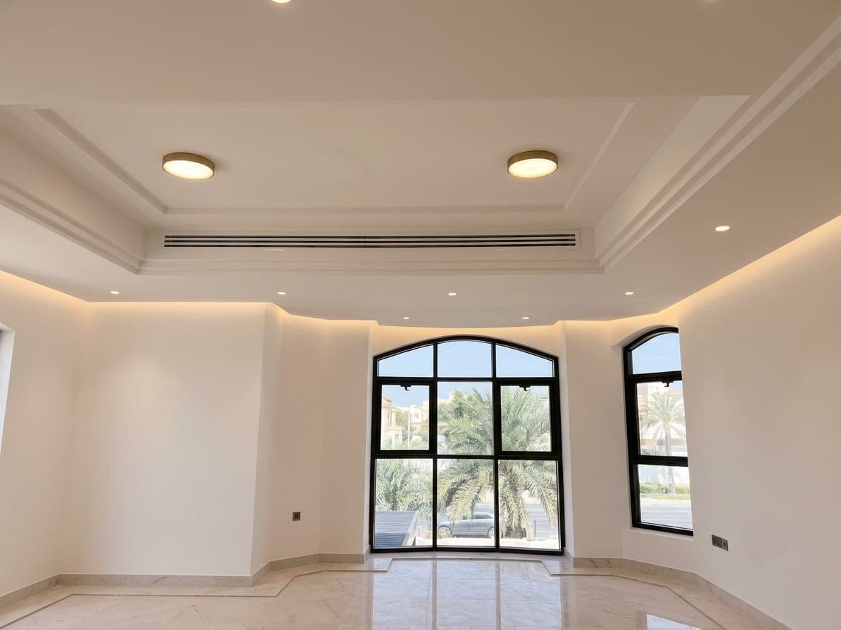 A room with black-steel arched glazing and a recessed tray ceiling