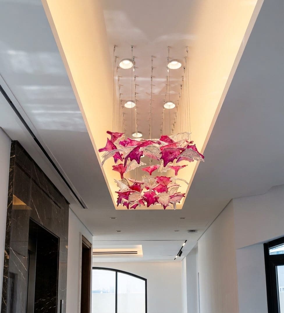 A cascading floral chandelier beneath a cove-lit ceiling