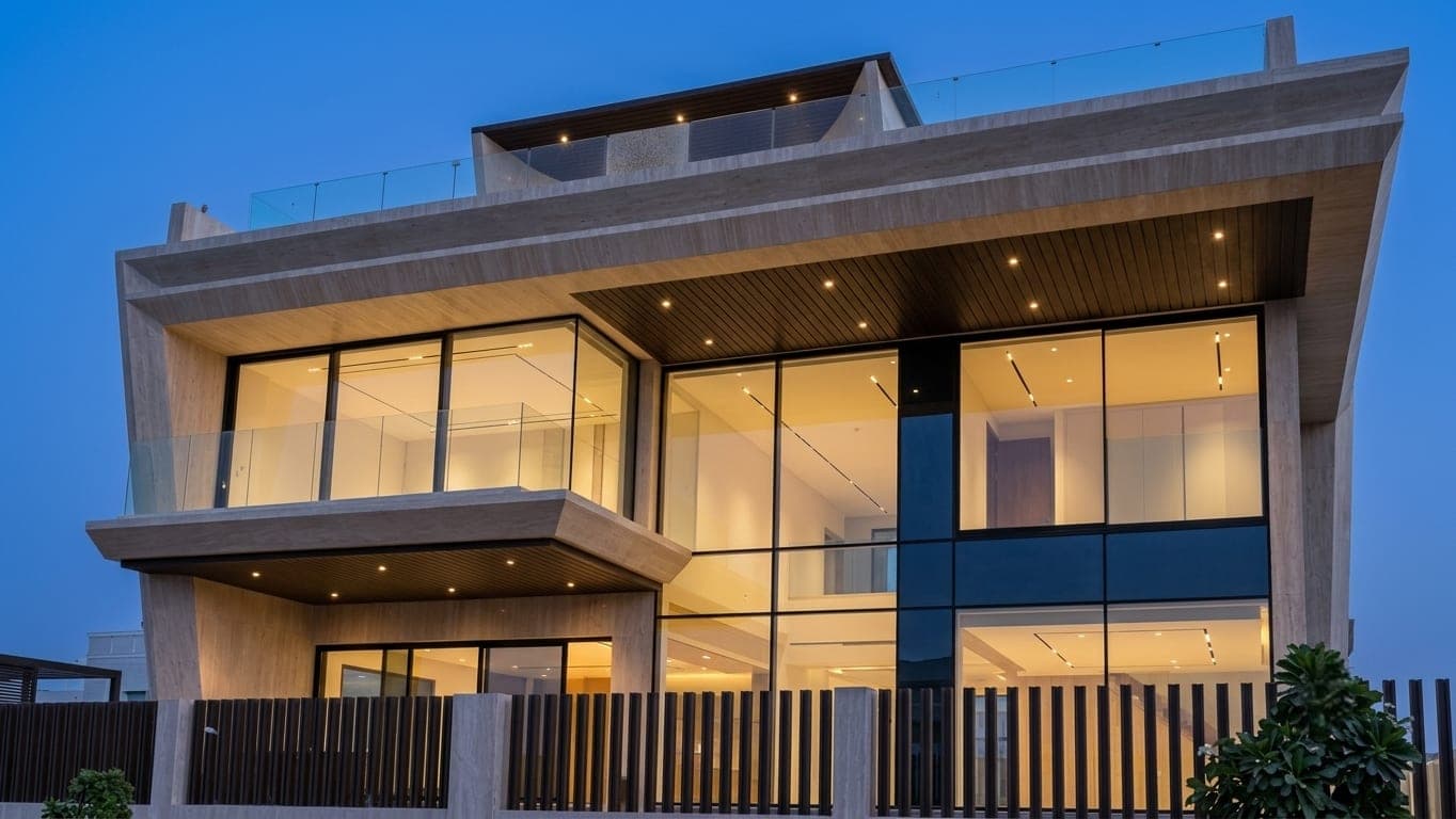 The villa's full front elevation at dusk