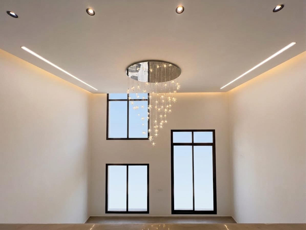 The double-height void with a cascading cloud chandelier between tall windows