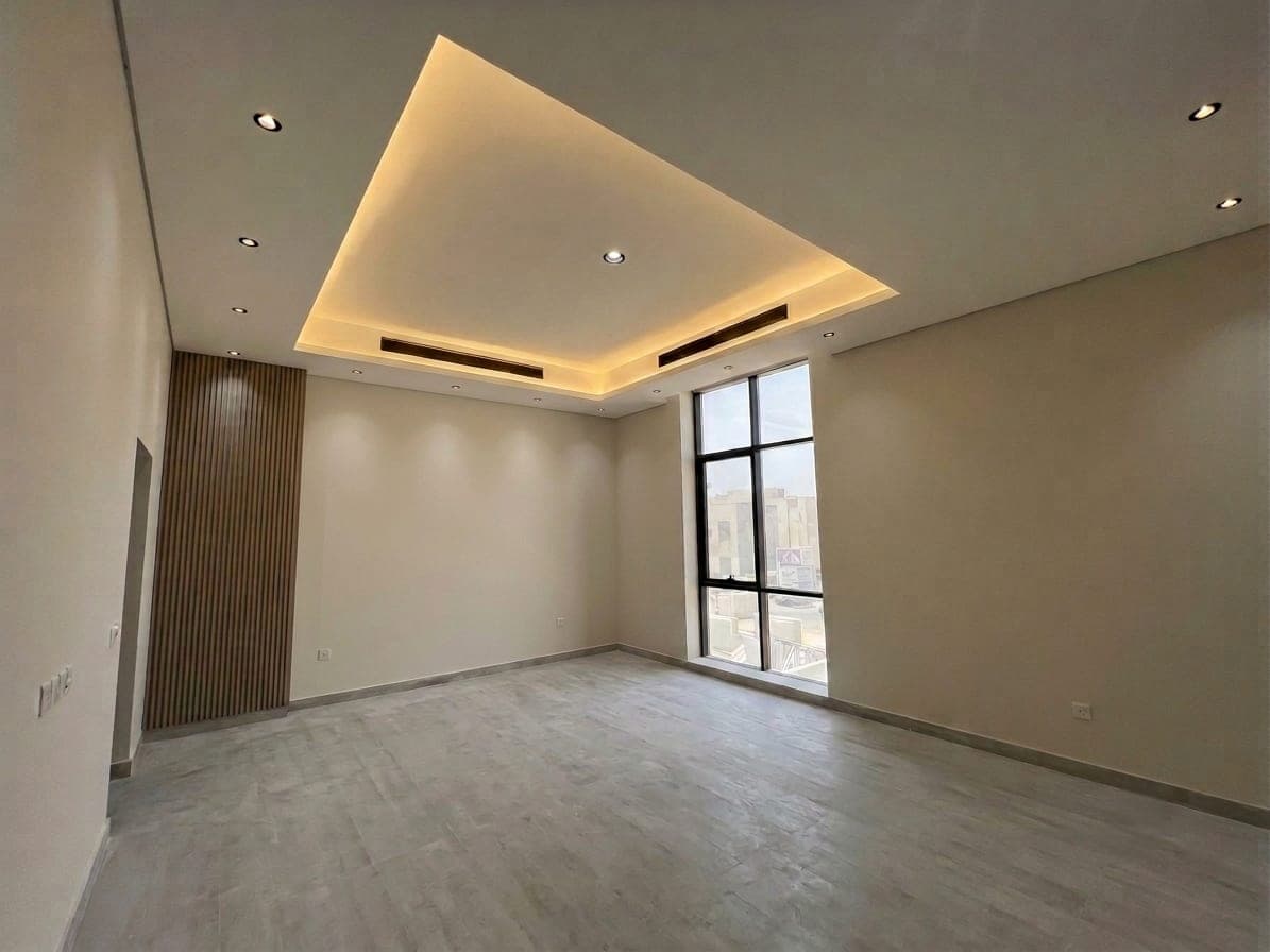 A reception room with a stepped cove ceiling and a timber accent wall