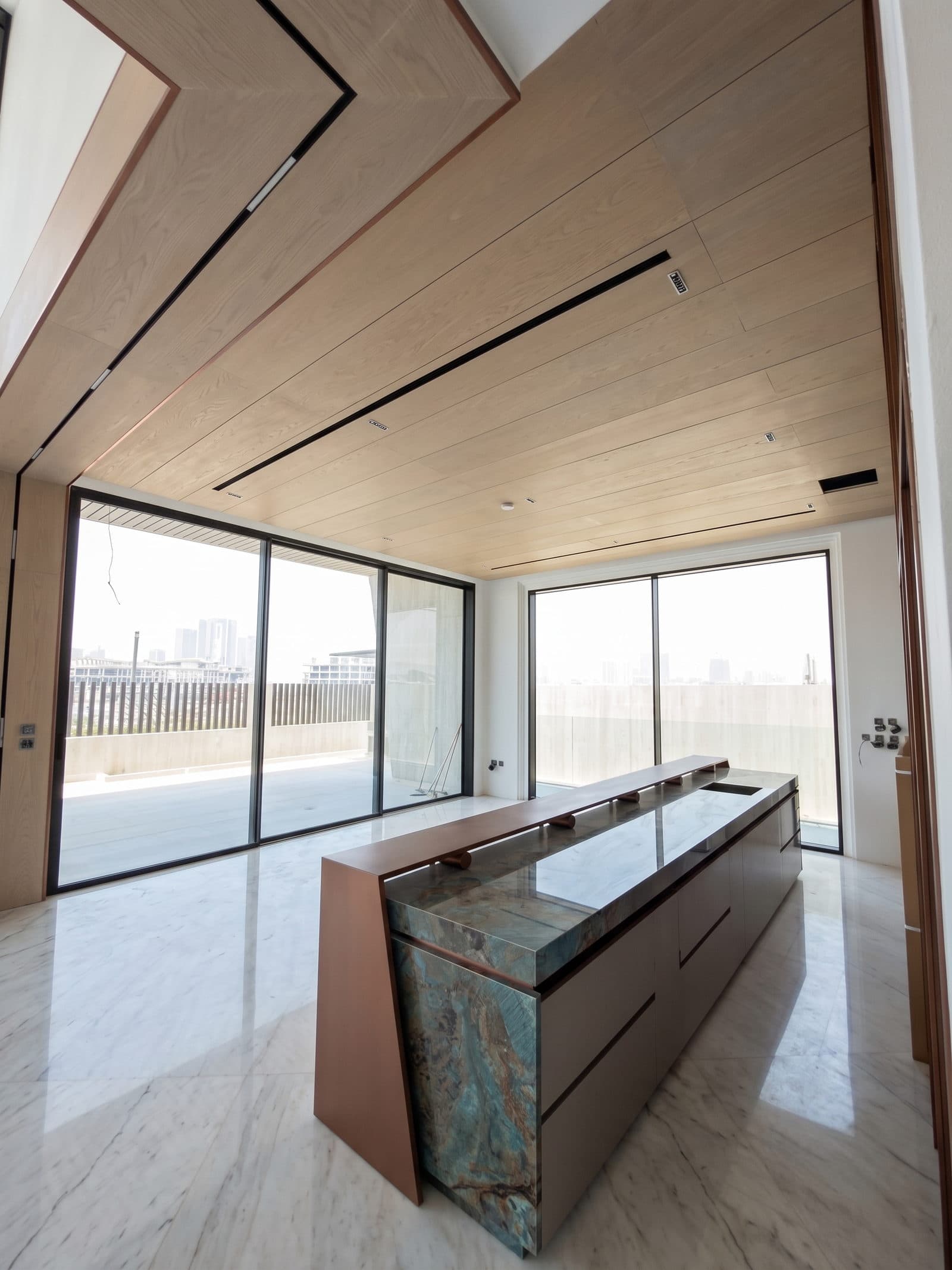 The island set against the kitchen's full-height glazing