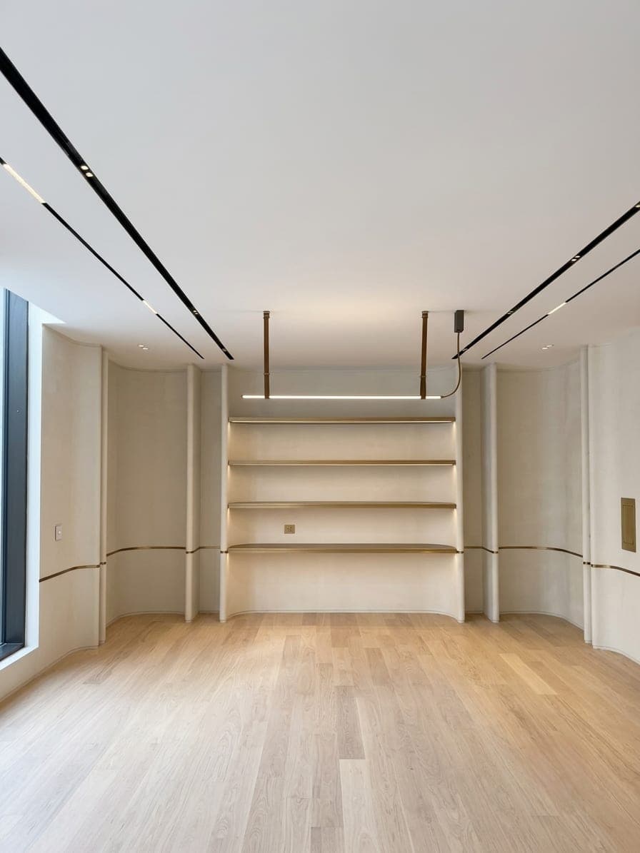 A room with a recessed shelving niche under a curved ceiling