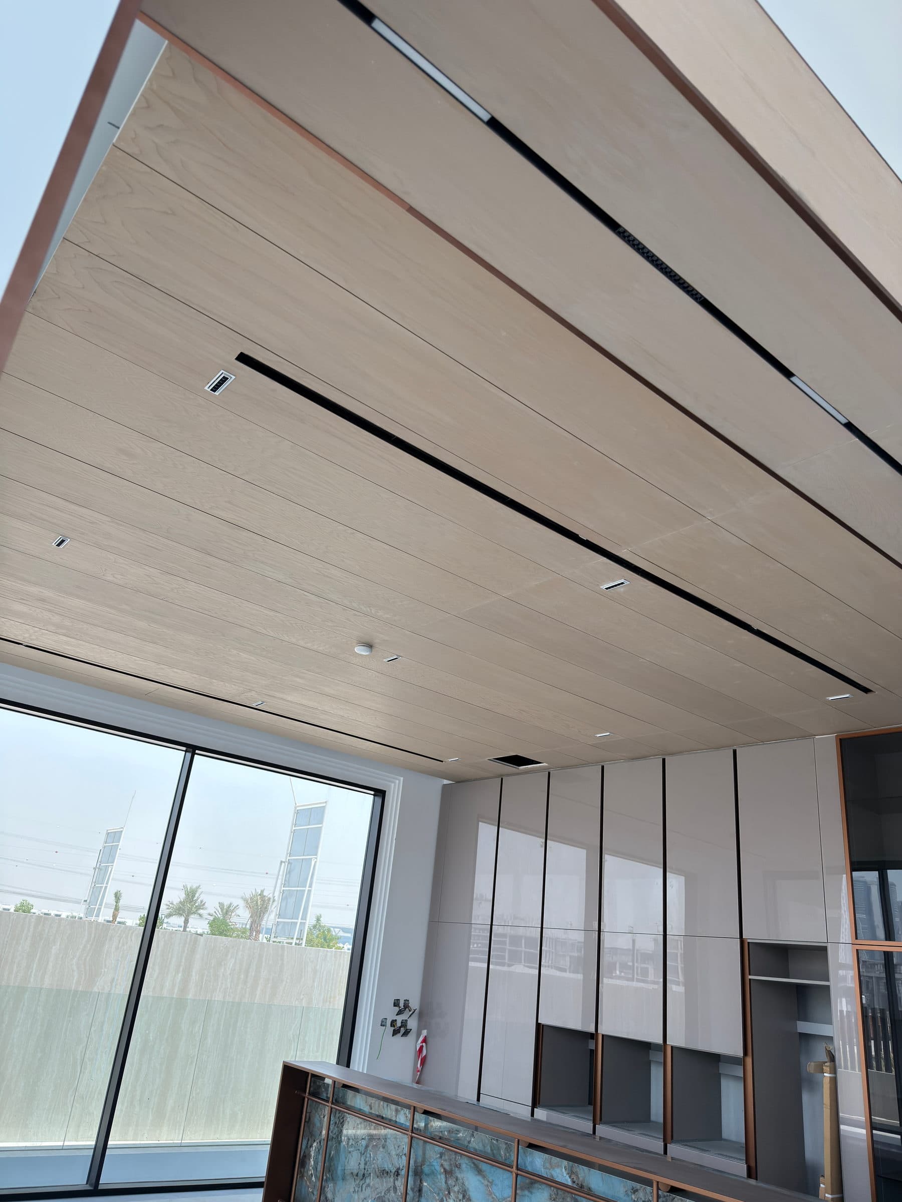 Oak-panelled ceiling and stair void in a completed villa interior.